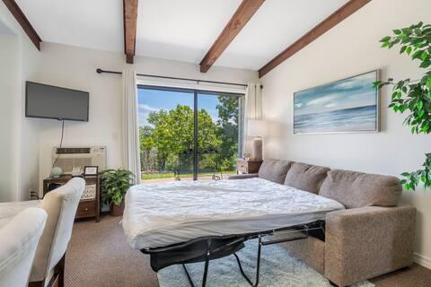 bedroom with carpet, a wall unit AC, and beam ceiling