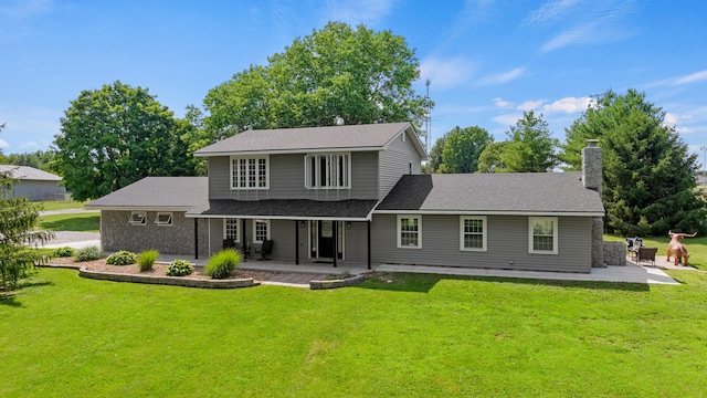 rear view of property with a patio and a lawn