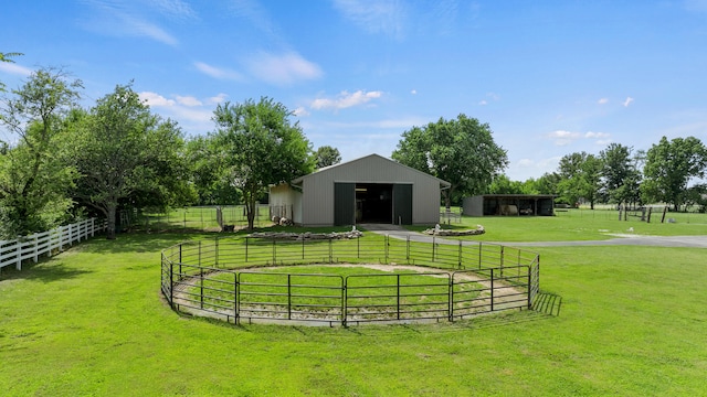 view of home's community featuring a rural view, an outdoor structure, and a yard