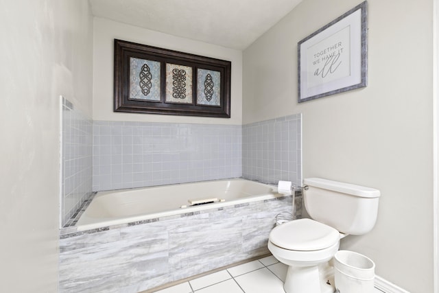 bathroom featuring tile patterned flooring, toilet, and tiled tub