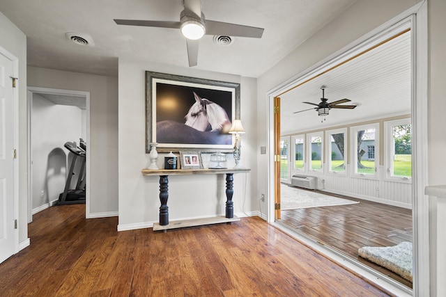 unfurnished living room featuring a wall mounted AC, ceiling fan, and dark hardwood / wood-style flooring