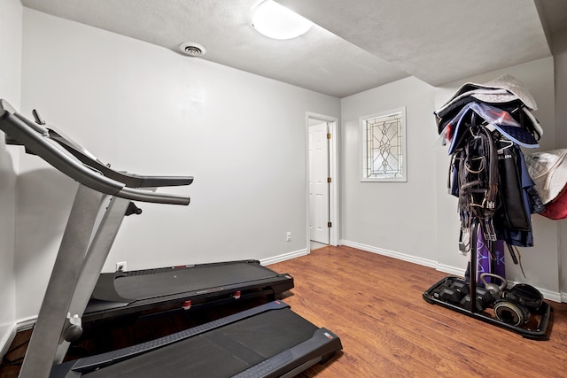 workout room with a textured ceiling and hardwood / wood-style flooring