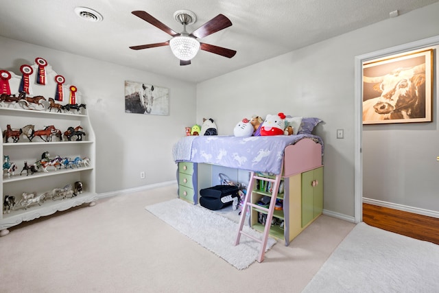 bedroom featuring a textured ceiling, carpet floors, and ceiling fan