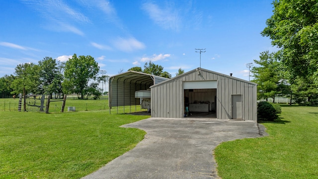 view of outdoor structure with a carport, a garage, and a lawn