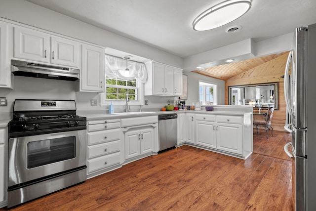 kitchen with kitchen peninsula, stainless steel appliances, sink, wood-type flooring, and white cabinetry