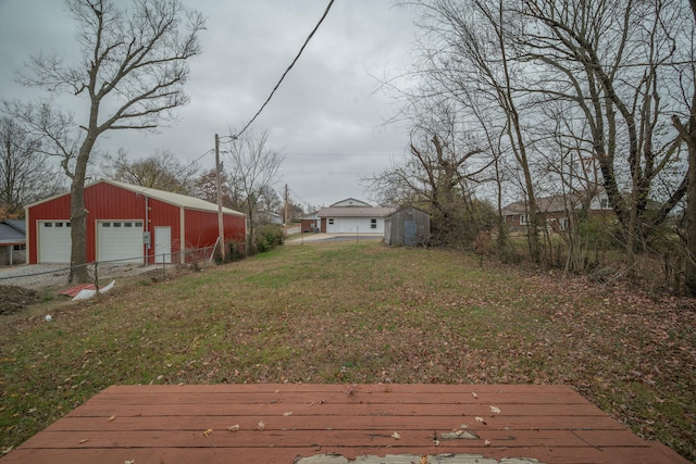 view of yard featuring a garage and an outbuilding