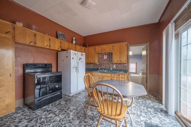 kitchen featuring electric range, white refrigerator with ice dispenser, and ornamental molding