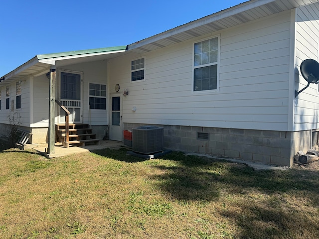 back of property featuring cooling unit and a yard