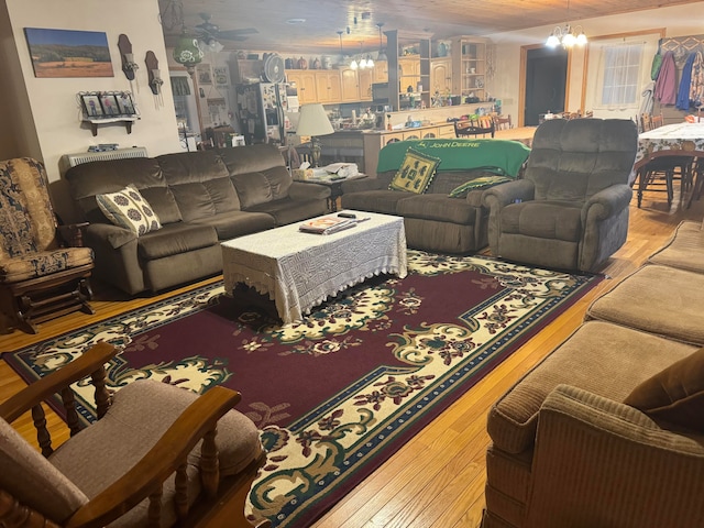 living room featuring wood-type flooring and ceiling fan with notable chandelier