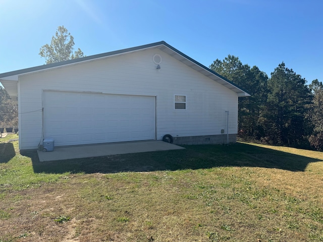 view of property exterior featuring a lawn, a garage, and an outdoor structure