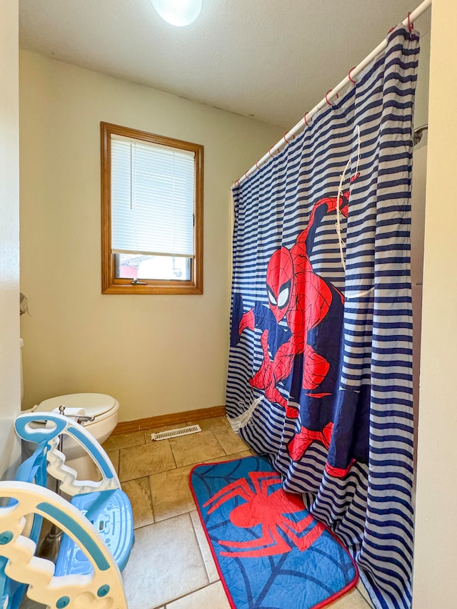 bathroom with tile patterned floors and toilet