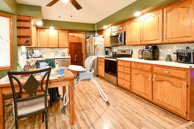 kitchen featuring backsplash, light hardwood / wood-style floors, and appliances with stainless steel finishes