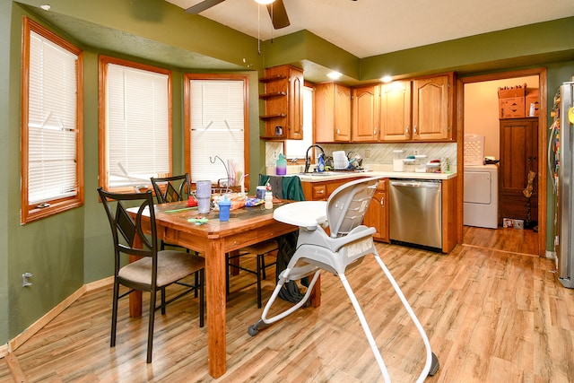 dining area with light hardwood / wood-style floors, washer / clothes dryer, ceiling fan, and sink