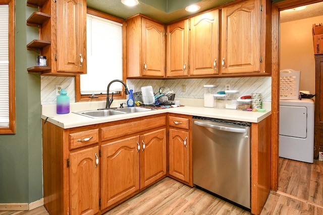 kitchen with dishwasher, sink, light hardwood / wood-style flooring, tasteful backsplash, and washer / dryer