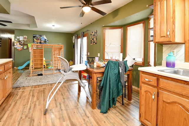 dining space with ceiling fan, sink, and light hardwood / wood-style flooring