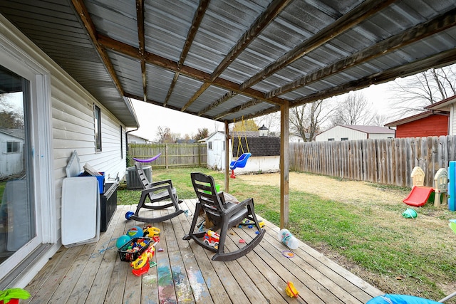 wooden deck featuring cooling unit, a storage shed, and a lawn