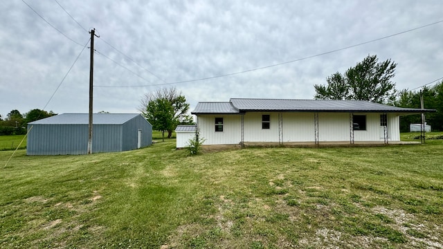 back of property with a yard and an outbuilding