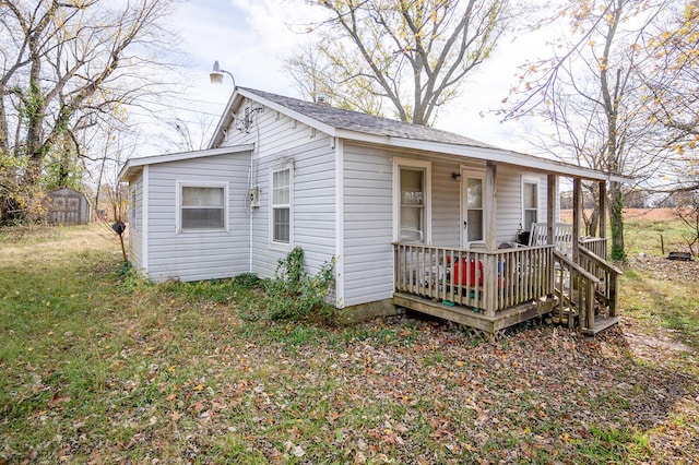 exterior space with covered porch, a storage shed, and a front yard