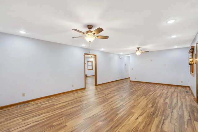 spare room with light wood-type flooring and ceiling fan