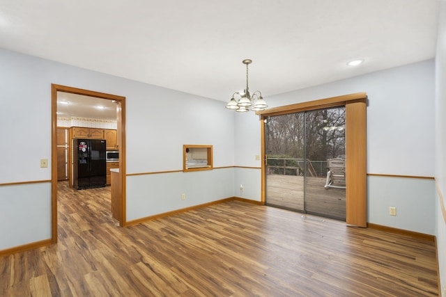 unfurnished dining area with hardwood / wood-style flooring and a notable chandelier