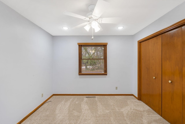 unfurnished bedroom with carpet floors, a closet, and ceiling fan