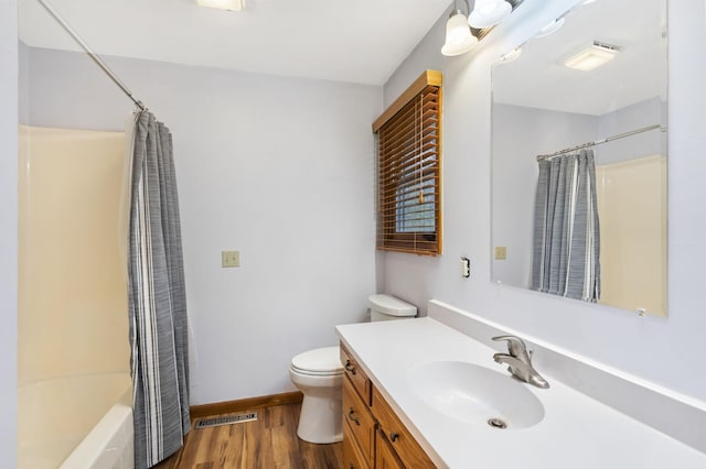 full bathroom featuring hardwood / wood-style flooring, vanity, toilet, and shower / tub combo with curtain