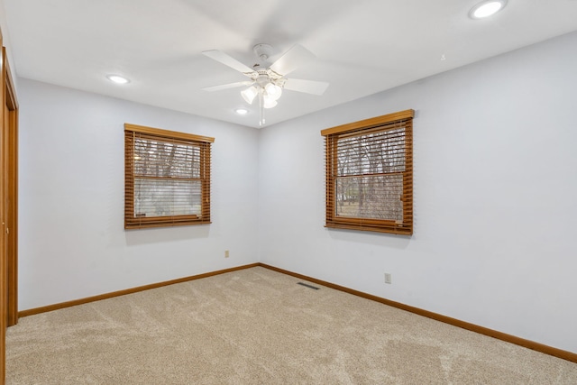 carpeted spare room featuring ceiling fan