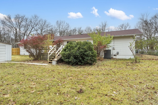 rear view of house with a lawn, cooling unit, and a wooden deck