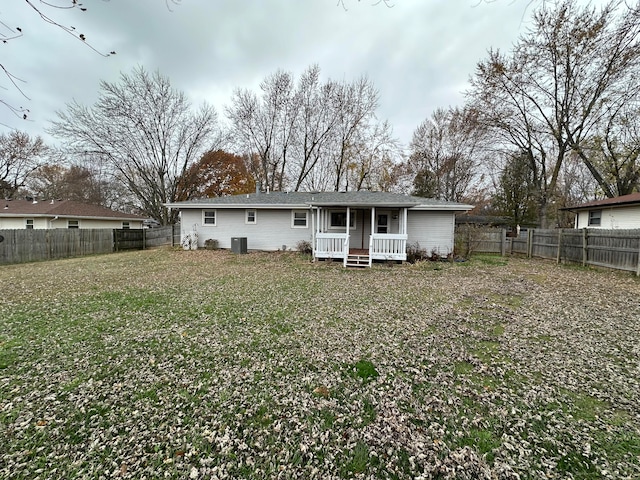 back of property featuring a lawn, a porch, and central AC