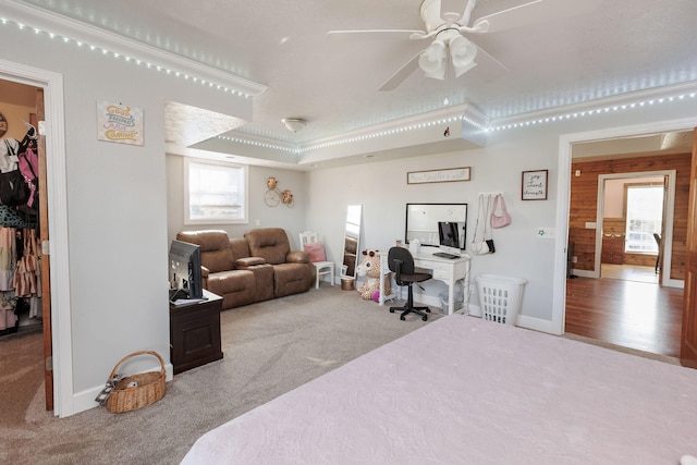 bedroom featuring a spacious closet, ceiling fan, light colored carpet, a tray ceiling, and a closet