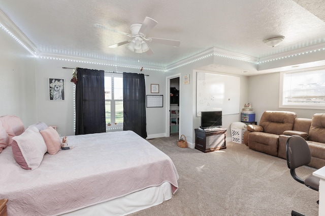 bedroom featuring light carpet, a textured ceiling, ceiling fan, and ornamental molding