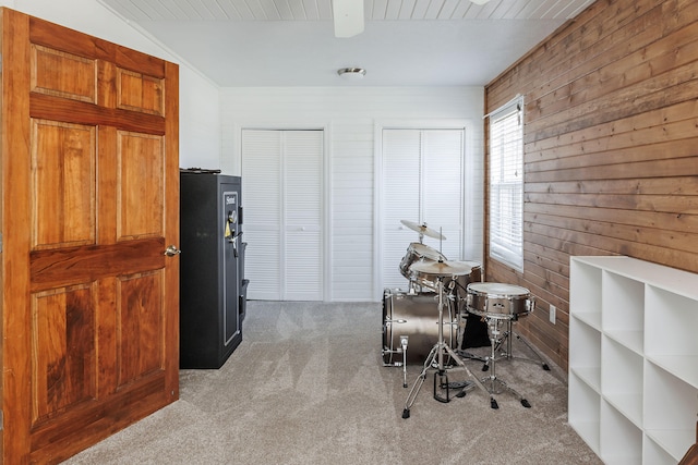 misc room with wood walls and light colored carpet