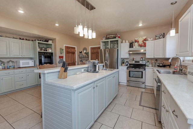 kitchen with white cabinetry, sink, hanging light fixtures, stainless steel appliances, and a kitchen island with sink