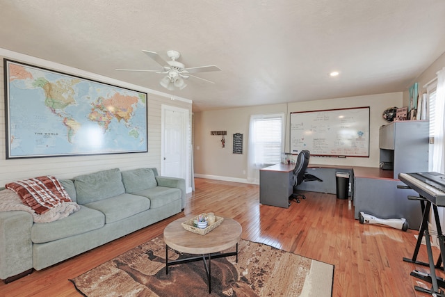 living room with light wood-type flooring and ceiling fan