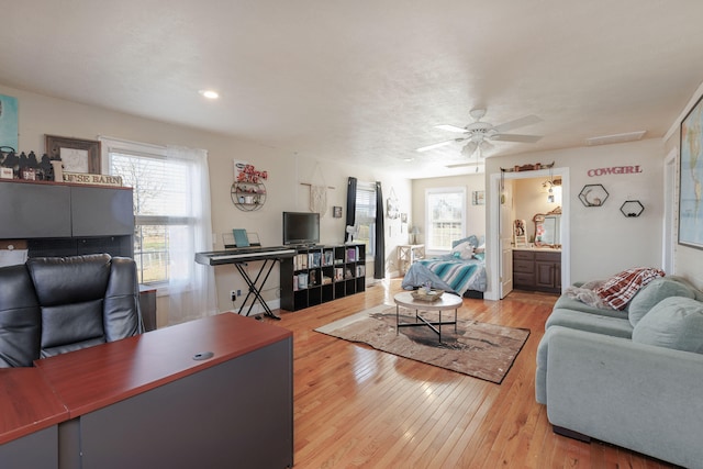 living room featuring light hardwood / wood-style flooring and ceiling fan