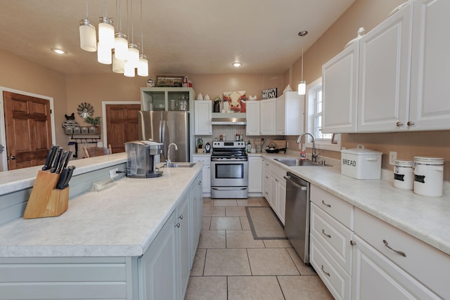 kitchen featuring white cabinets, appliances with stainless steel finishes, hanging light fixtures, and sink