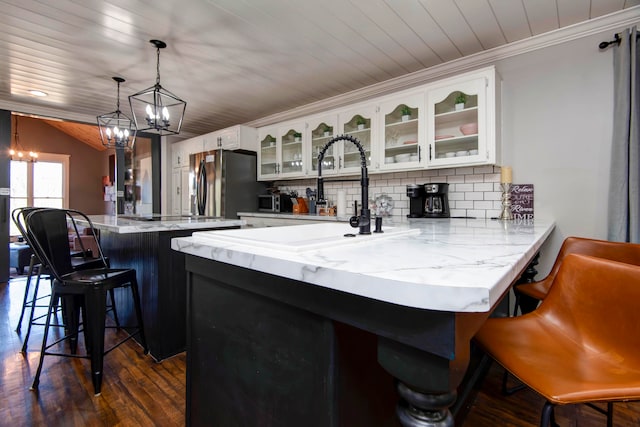 kitchen with stainless steel fridge with ice dispenser, dark hardwood / wood-style floors, decorative light fixtures, a breakfast bar area, and white cabinets