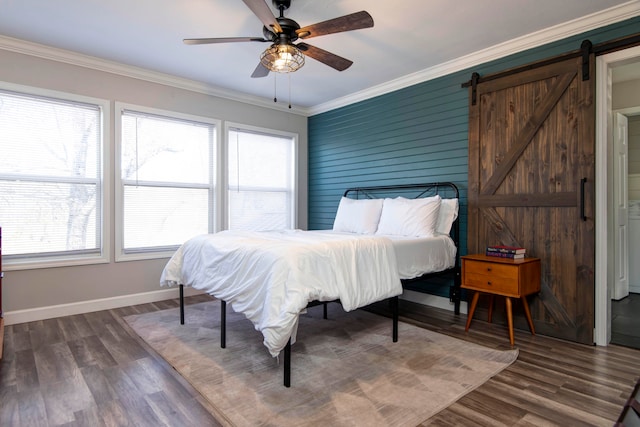 bedroom featuring a barn door, ceiling fan, dark hardwood / wood-style floors, and ornamental molding