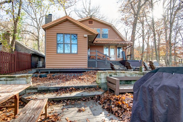 back of house with a wooden deck, central AC unit, and a hot tub