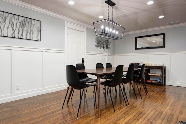 dining room with dark hardwood / wood-style flooring, ornamental molding, and a notable chandelier