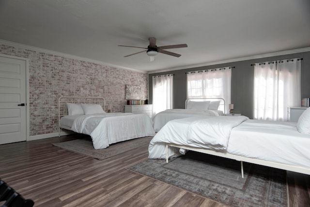 bedroom featuring ceiling fan, dark hardwood / wood-style flooring, crown molding, and brick wall