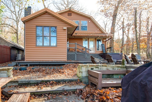 rear view of house featuring a hot tub