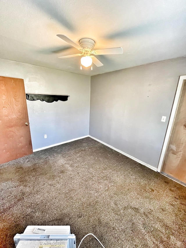 carpeted spare room with ceiling fan, a textured ceiling, and baseboards