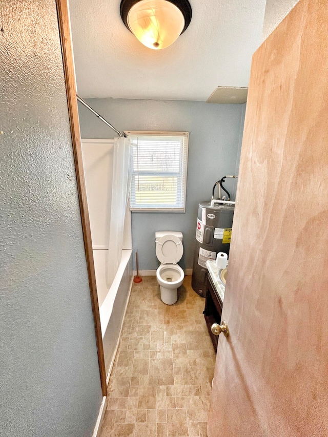 bathroom featuring baseboards, toilet, vanity, electric water heater, and shower / bathtub combination