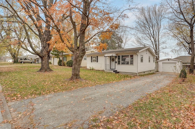 view of front of property featuring an outdoor structure, a front yard, and a garage