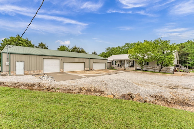 view of front of house with a garage, an outbuilding, and a front lawn