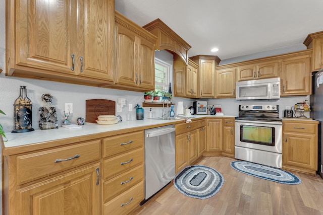 kitchen featuring light wood-type flooring, sink, and appliances with stainless steel finishes