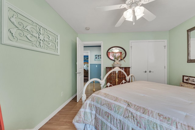 bedroom with a closet, light hardwood / wood-style flooring, and ceiling fan