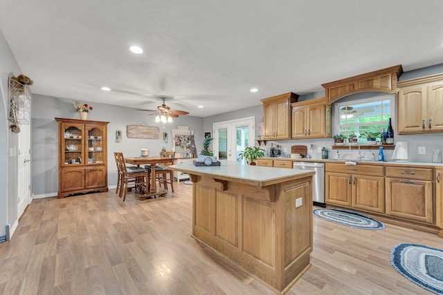 kitchen featuring a center island, light hardwood / wood-style floors, stainless steel dishwasher, and sink