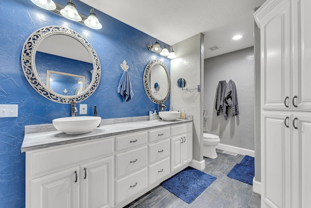 bathroom with vanity, wood-type flooring, and toilet